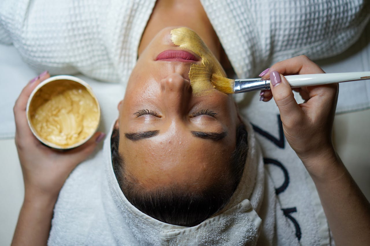 Crafting Captivating Headlines: Your awesome post title goes here A woman enjoying a gold facial mask for relaxation and skincare at a spa.