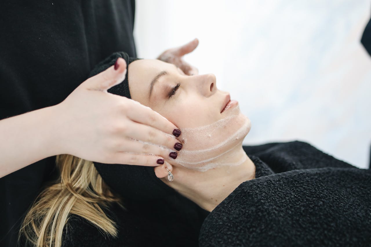 Mastering the First Impression: Your intriguing post title goes here Side view of a woman receiving a soothing facial treatment at a spa, promoting wellness and skincare.
